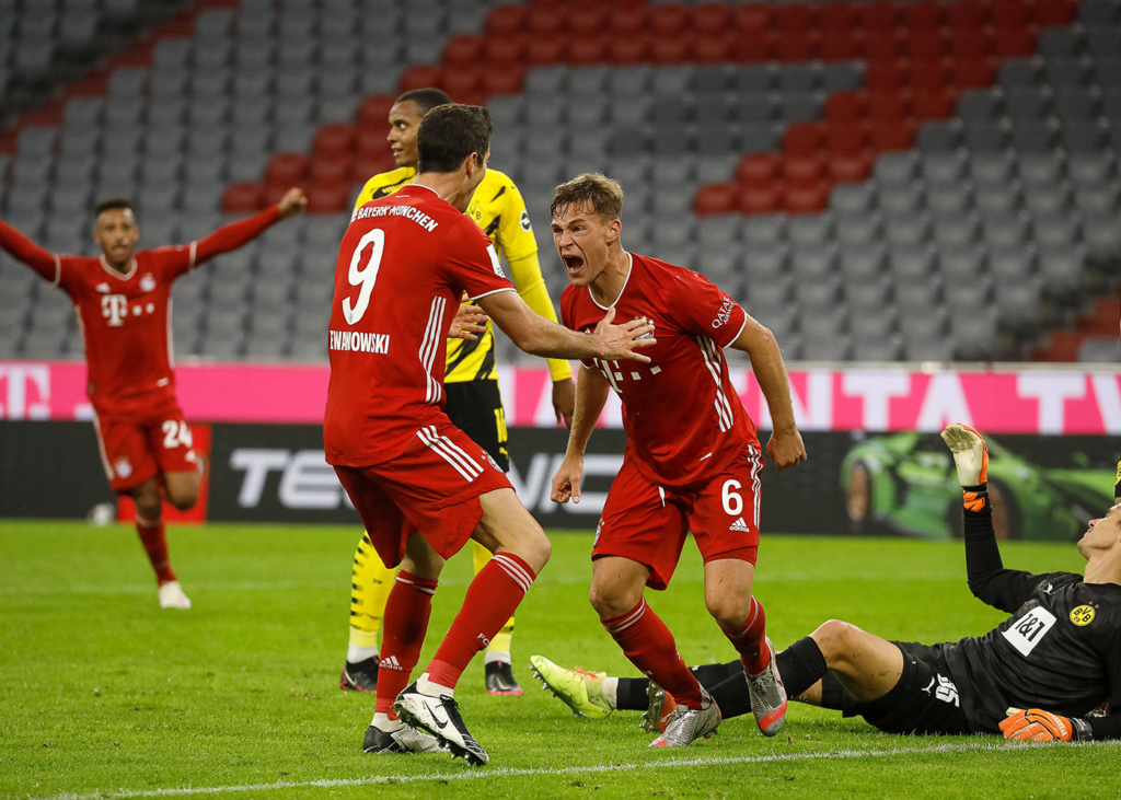 Joshua Kimmich und Robert Lewandowski vom FC Bayern jubeln vor Dortmunder Spielern.